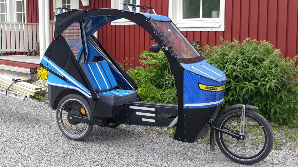 Threewheeler delta velocar with direct steering, foldable doors, cargo capacity on the roof.